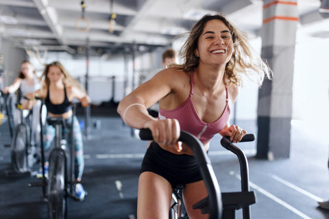 a woman works out on the air bike in the gym