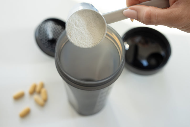A scoop of creatine is added to a shaker