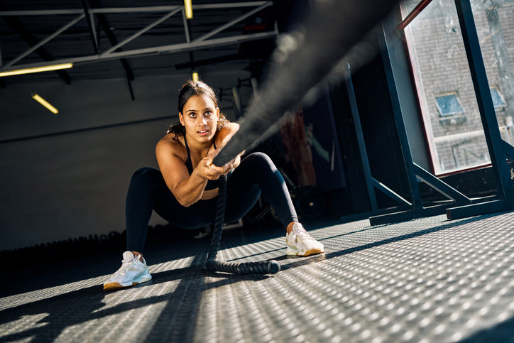 Close up of a woman doing a sled pull in the gym