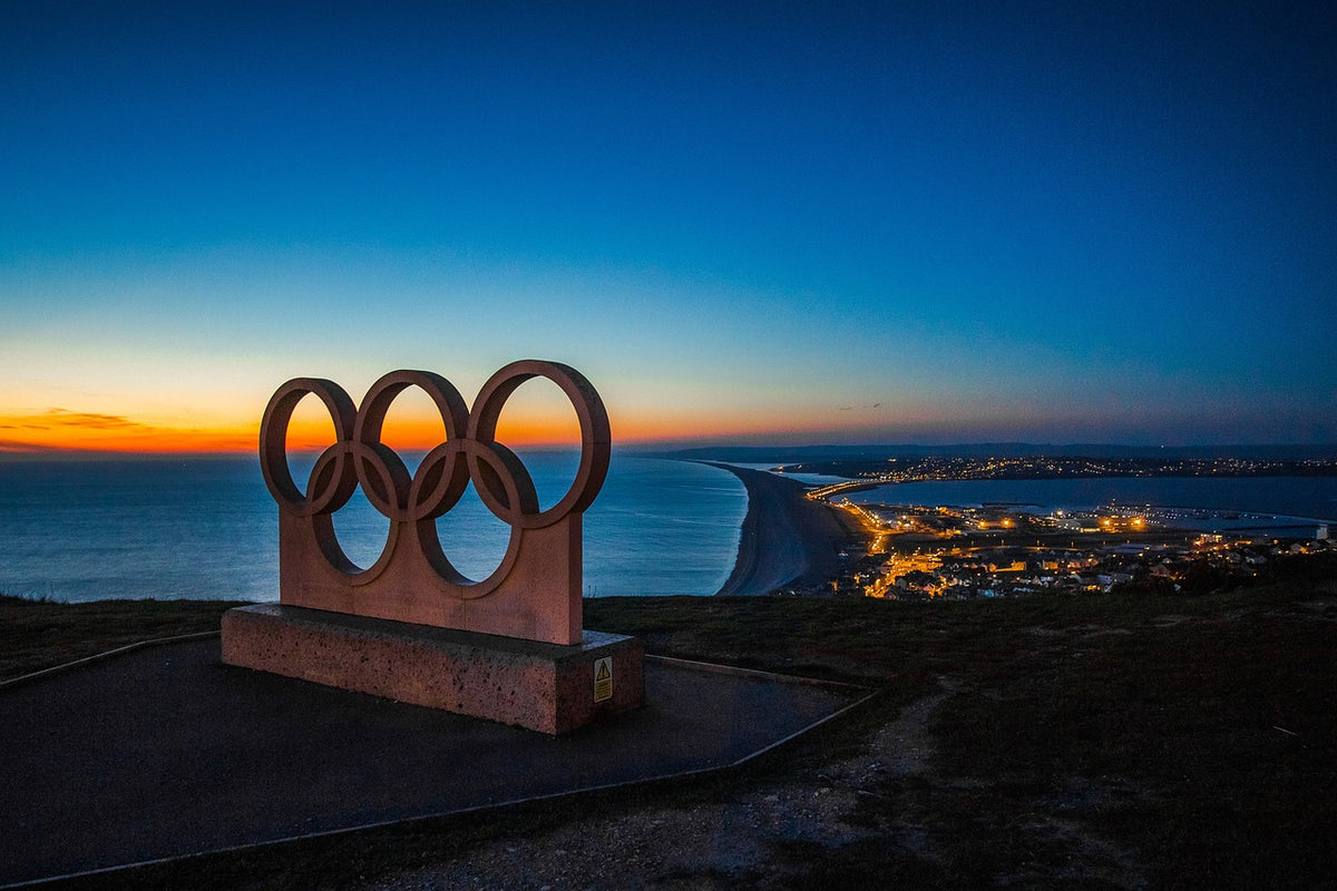 The Olympic rings set against a coastal backdrop