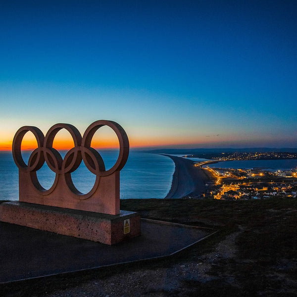The Olympic rings set against a coastal backdrop